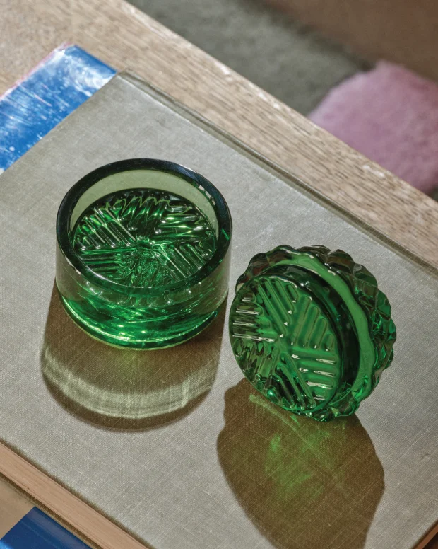 Two green glass grinders on a linen book