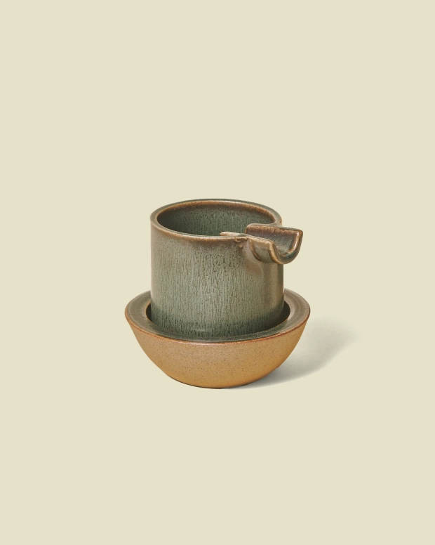 Ashtray by Seth in Moss: a grey-green ashtray nested in a sand-coloured saucer