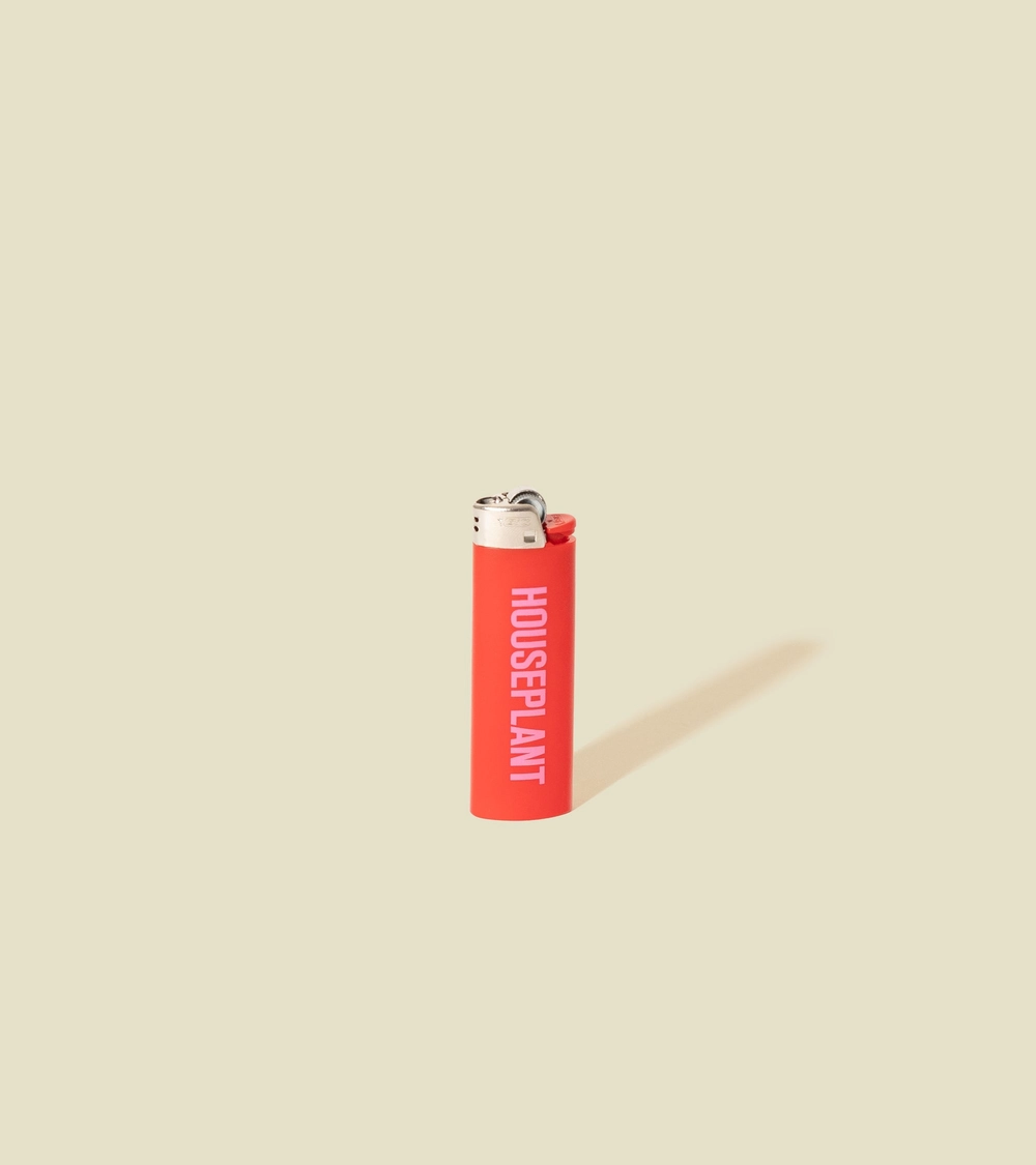 The Sidekick Lighter in red, standing on a cream background
